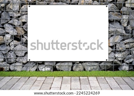 Advertising billboard with empty white mockup, square wooden poster on stone textured wall. Blank template. Fragment of a wall from a chipped stone.
