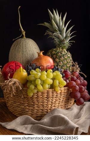 Still life of fruit in a basket on a black background.