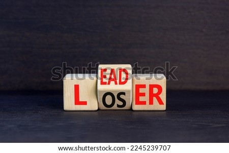 Leader or loser symbol. Concept word Leader Loser on wooden cubes. Beautiful black table black background. Business and leader or loser concept. Copy space.