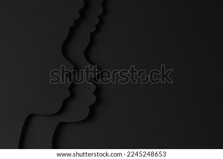 Black History Month color background. African Americans history celebration. Black paper cut people silhouette on abstract black color background. Top view