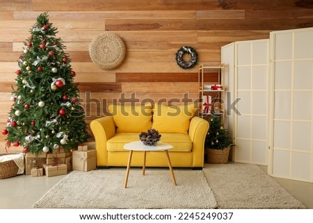 Interior of living room with Christmas tree, presents and yellow sofa