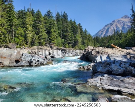 Rushing river flowing from a mountain set beside a forest in Kootenay National Park in B.C. Canada Royalty-Free Stock Photo #2245250503