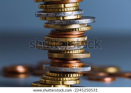 Stack of coins close up with blurred background. Euro coins stacked in a pile. Soft focus.