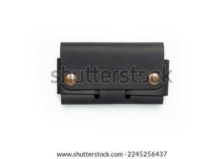 Small black leather wallet on a button on a white background. Top view