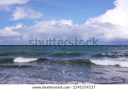 Seascape with stormy sea waves with foam under heavy cumulonimbus on the sky till horizon