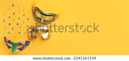 Carnival masks on orange background with space for text