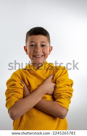 Confident Caucasian little boy smiling arms crossed looking at the camera isolated on a white background - people lifestyle concept, vertical.