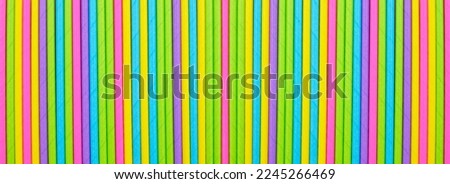 Close up many colored paper straw pattern background. Flat lay cocktail tube abstract vertical line texture