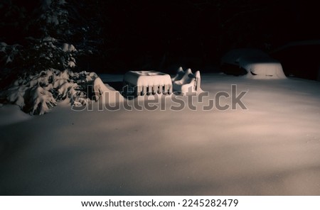 Snowy bench made of pallets at dark night