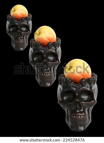 Spooky skulls with apple on black background. Great for halloween.