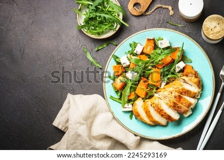 Warm salad with baked chicken breast, pumpkin, blue cheese and arugula. Dash diet, keto diet meal. Top view with copy space. Royalty-Free Stock Photo #2245293169