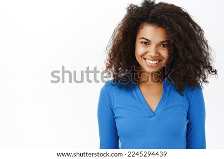 Haircare and beauty. Young curly black woman laughing, smiling, hair looks fresh and shiny, white smile, perfect skin without blemishes, studio background Royalty-Free Stock Photo #2245294439
