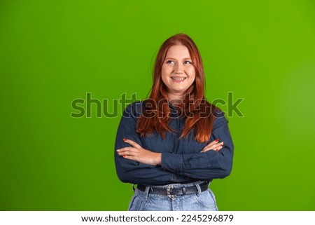 young redhead woman with arms crossed smiling with free space for text