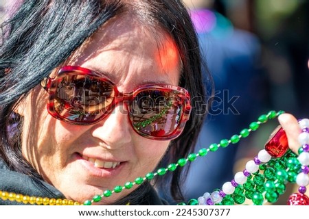 Happy woman at New Orleans carnival on Mardi gras major event holds famous beads.