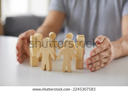 Little wooden man and recruiter hands symbolize team building activities for human resources creation of effective team professionals working for company or startup. Business concept, HR strategy