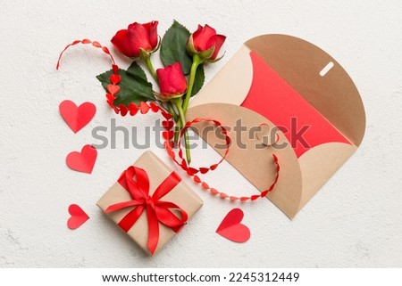 Valentine day composition with envelope, rose flower and red heart on table. Top view, flat lay, copy space Holiday concept.