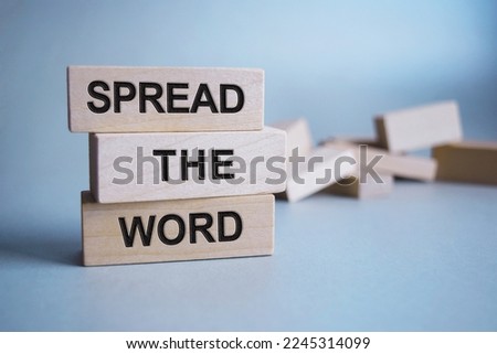 The inscription SPREAD THE WORD on wooden cubes isolated on a light background, the concept of business and finance.