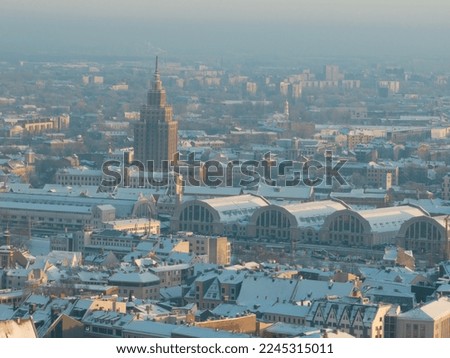  a view of a city with a lot of snow on the ground and buildings in the background with a sky line in the middle of the picture, and a few buildings in the foreground. . 