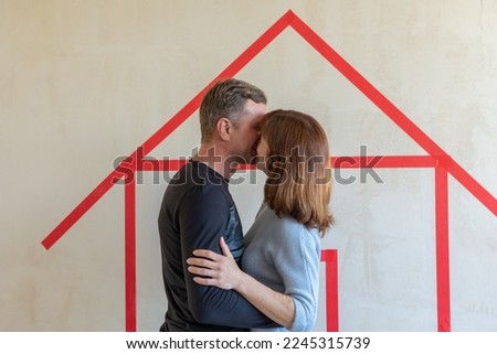 Man hugging his wife. Young couple moving in new apartmen. View from side. Concept new homes, new beginning. High quality photo