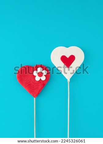 Creative testy heart lollipop composition on pastel blue background. Minimal love, concept. Valentine's day. Empty space.