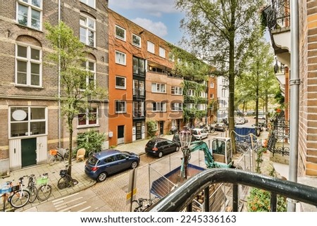 an urban street with parked cars and bicycles in amsterdam, the netherlands - stockfoorenlimm com Royalty-Free Stock Photo #2245336163