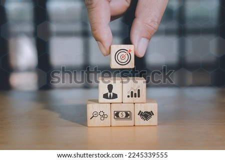 Concept of business strategy or e-commerce with shopping icons on wooden cubes against blue background. Business achievement goal and growth success objective concept.