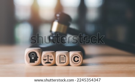 wooden blocks and Wooden judge gavel on the table, concept of copyright or intellectual property patent protection of copyright infringement proprietary declaration Legitimate innovations Royalty-Free Stock Photo #2245354347
