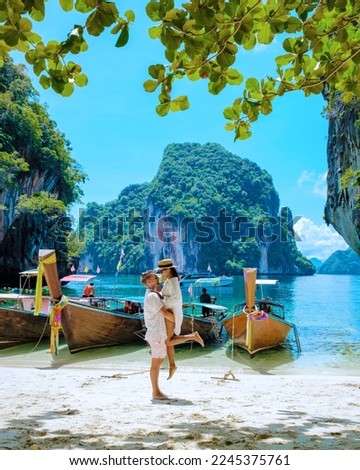 Koh Lao Lading near Koh Hong Krabi Thailand, a beautiful beach with longtail boats, a couple of European men, and an Asian woman on the beach. Couple on a boat trip Royalty-Free Stock Photo #2245375761