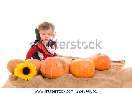Halloween baby boy in dracula costume with pumpkins