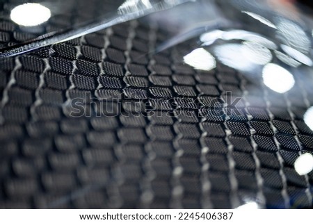 The pattern of the carbon fiber bonnet under the light reflects the moving image