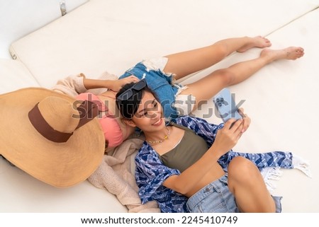 Asian woman using mobile phone taking selfie during travel on luxury catamaran boat yacht sailing in the ocean with friends. Attractive girl enjoy outdoor lifestyle on summer beach holiday vacation.