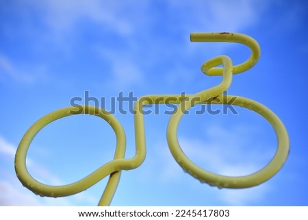 A sign for a bicycle parking lot that looks like it's running in the blue sky.