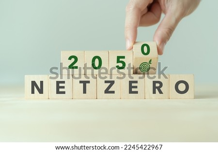Net zero by 2050. Green business and sustainability. Net zero greenhouse gas emissions target. Limit climate change strategy. Flipping wooden cubes  with net zero target icon on minimal background. Royalty-Free Stock Photo #2245422967