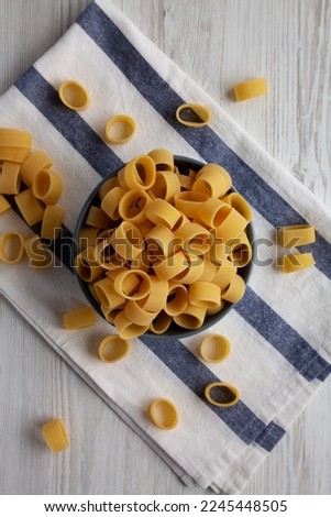 Raw Uncooked Pasta Calamarata in a Bowl, top view. Flat lay, overhead, from above. Royalty-Free Stock Photo #2245448505