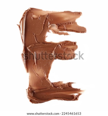 Cream chocolate spreading in shape letter E, alphabet isolated on white, clipping path, top view