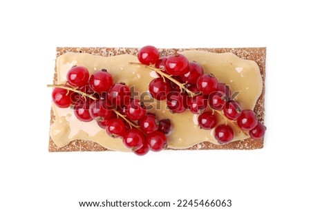 Fresh crunchy rye crispbread with peanut butter and red currant isolated on white, top view Royalty-Free Stock Photo #2245466063