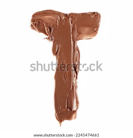 Cream chocolate spreading in shape letter T, alphabet isolated on white,  top view