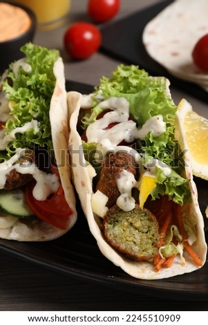 Delicious fresh vegan tacos served on wooden table, closeup