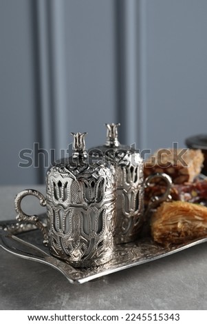 Tea, baklava dessert and Turkish delight served in vintage tea set on grey textured table
