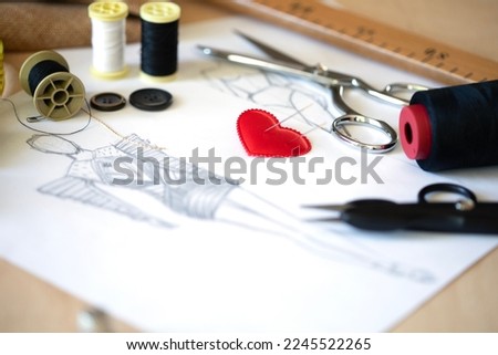 tailor's tools on dress designers table