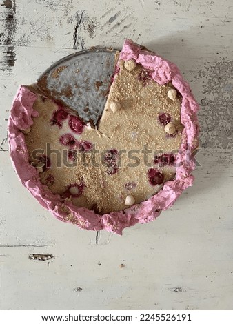 Tart with raspberry on a white wood table