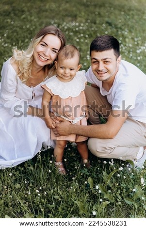 Happy stylish family: Photo of a young family enjoying a vacation in a park in a summer countryside