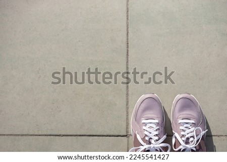 pink new sneakers stand on gray paving stones. Place for text. View from above