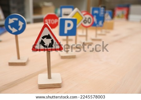 Different miniature road signs on wooden table, space for text. Montessori toy