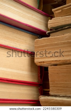 A stack of old books shooting up close. Old paper in books - a large stack - vertical photo. Ancient books in a stack.