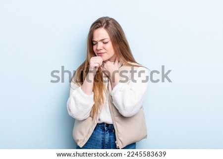 caucasian red hair woman feeling ill with a sore throat and flu symptoms, coughing with mouth covered Royalty-Free Stock Photo #2245583639
