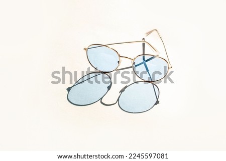 Blue stylish sunglasses on a white background. Contrasting shadows. Concept summer fashion glasses