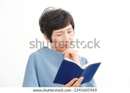 Asian senior woman reading the book in white background