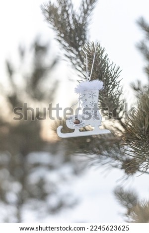 Retro ice skates decoration hanging on the pine tree outdoors in winter on the snowy background