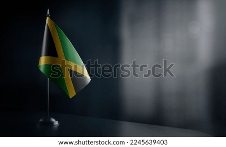 Small national flag of the Jamaica on a black background.